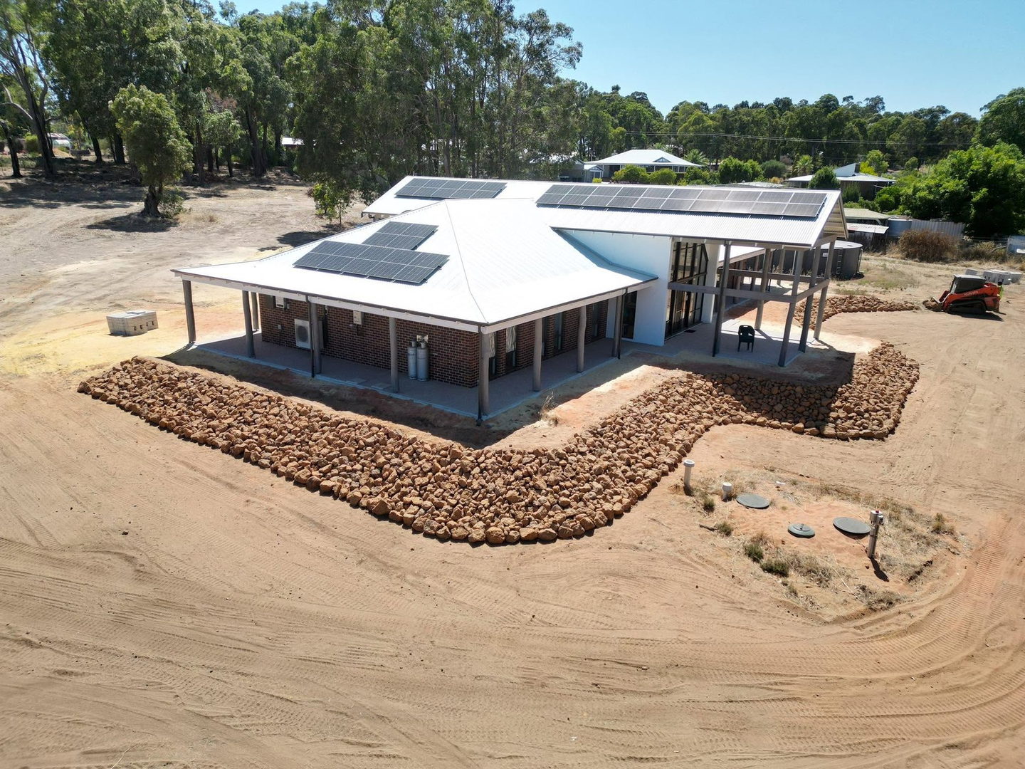 Aerial of a finished house pad with rock edging